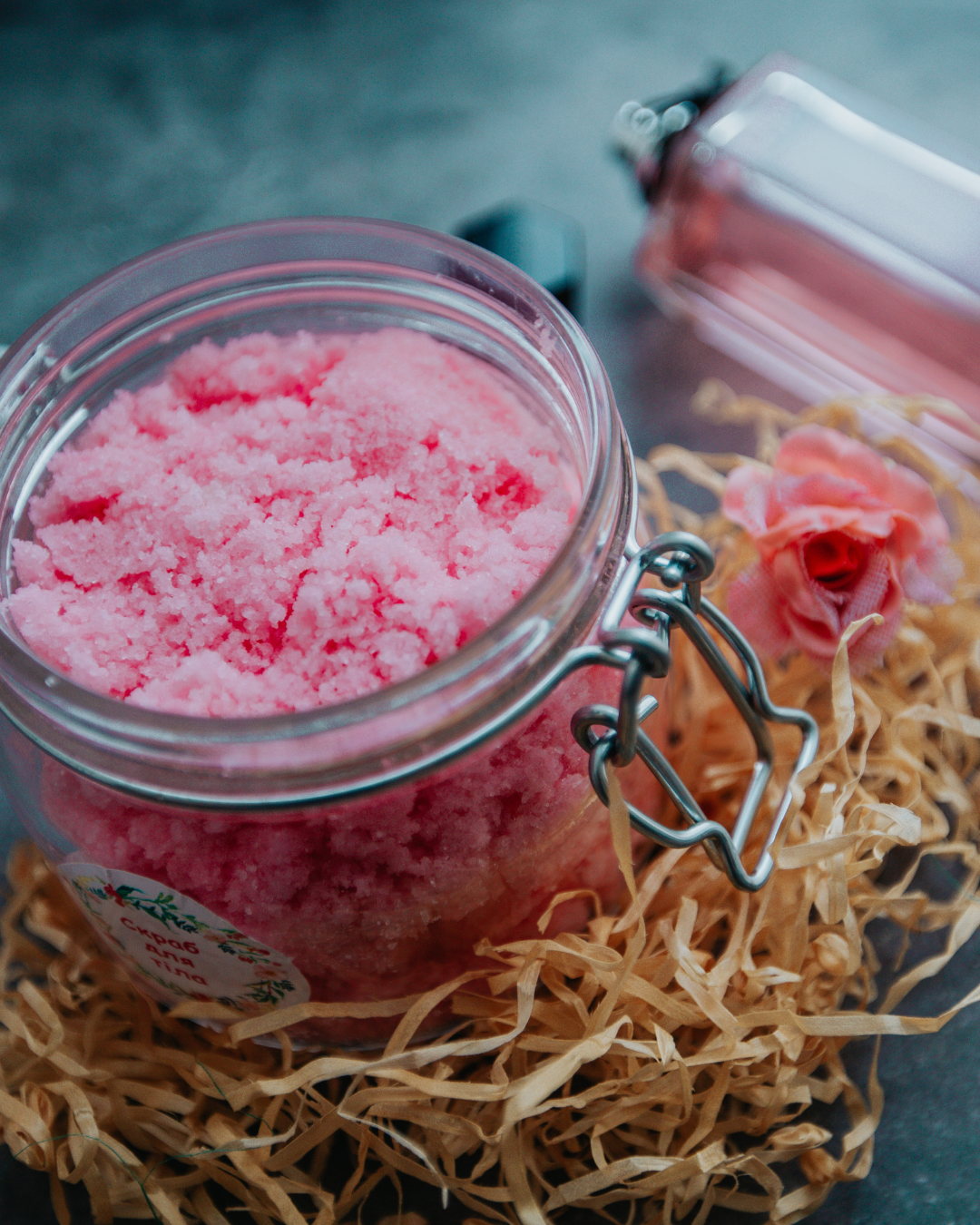 Gommage corporel maison à la texture rose, présenté dans un pot en verre avec ingrédients naturels, idéal pour les soins du corps et les ateliers cosmétiques DIY Khanalyä.